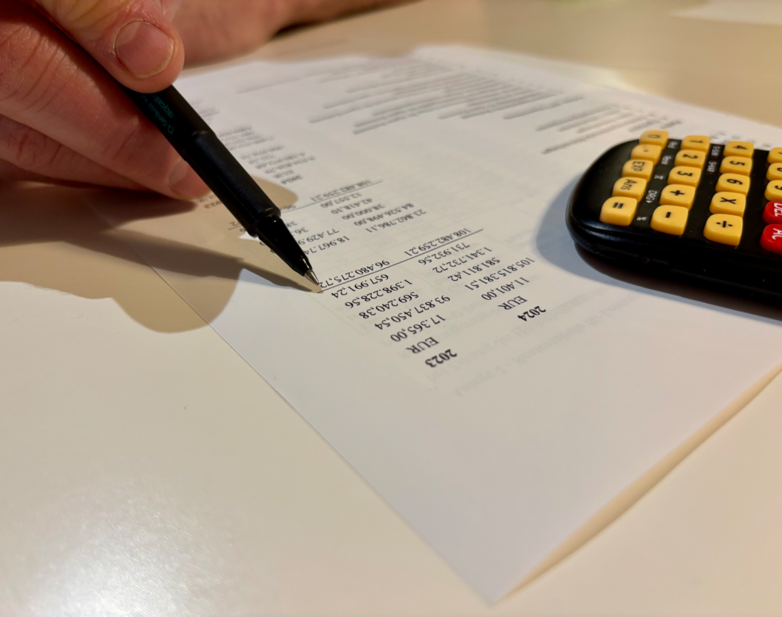 Taschenrechner und Stift mit Zahlenanalyse